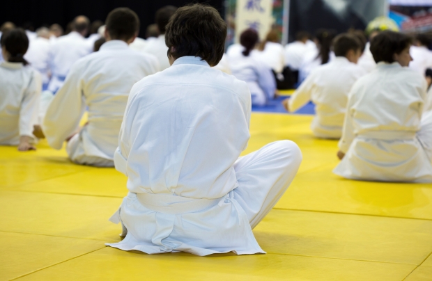 People in kimono warming up on tatami on martial arts training seminar