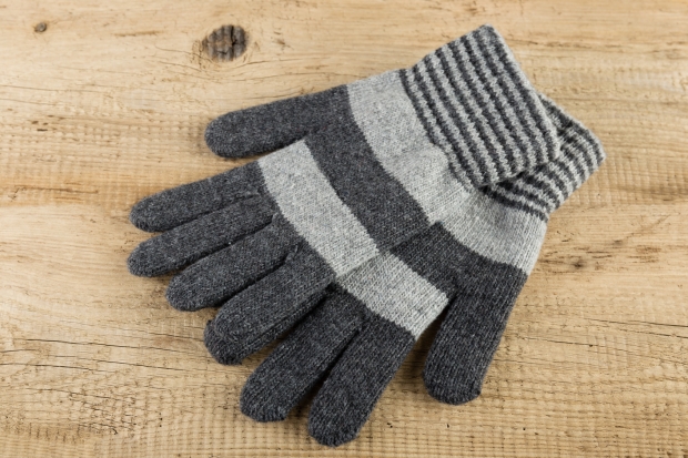 Knitted gloves on wooden background