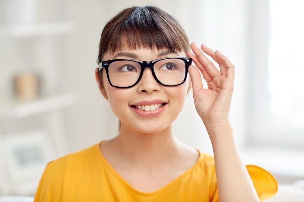 people, education, vision and portrait concept - happy asian young woman or teenage student girl in glasses at home